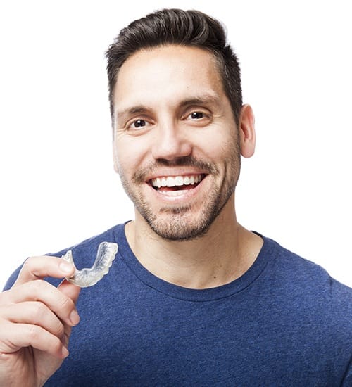 Smiling man holding an orthodontic clear aligner tray