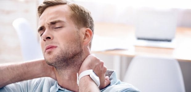 Man in need of T M J therapy holding neck in pain