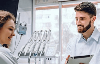 Woman speaking with dentist while sitting in dental chair