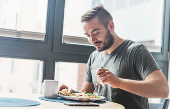 Man sitting at table eating breakfast
