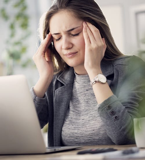 Woman in need of sleep apnea therapy holding her head