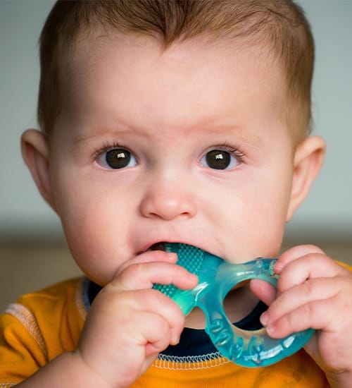 Toddler chewing on teething ring