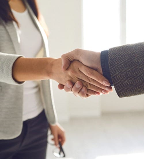 Two people greeting each other and discussing dental insurance