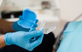 Dentist holding case and clear aligner in San Ramon, CA