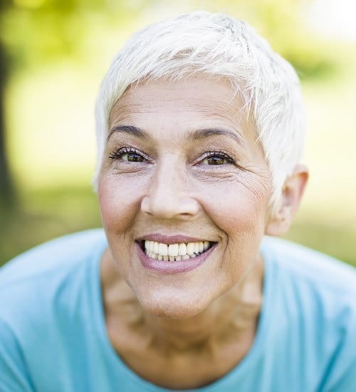 Woman sharing flawless smile after advanced treatment using C T cone beam scans