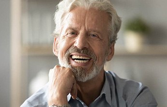 Senior man resting hand on chin and smiling