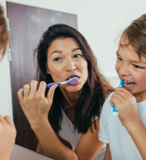 Mother and son and brushing their teeth together
