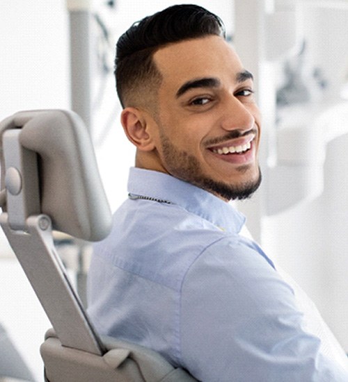 Bearded man sitting in a dental chair and smiling