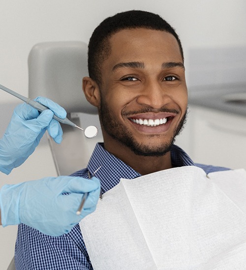 Man smiling in the dental chair during implant checkup