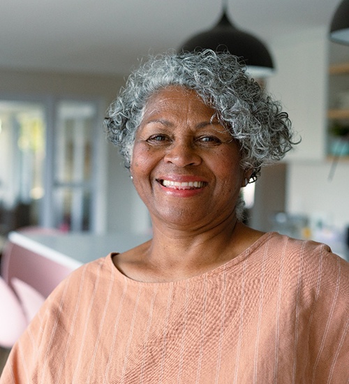 Senior woman in peach colored shirt smiling