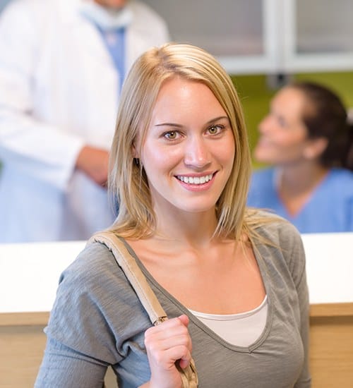 Woman smiling after maximizing dental insurance benefits at dentist