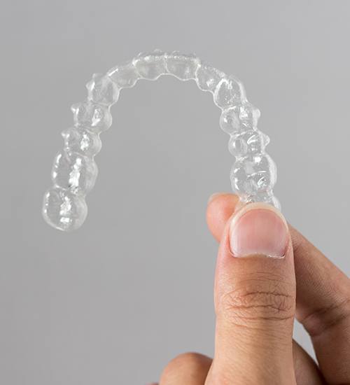 Hand holding an orthodontic aligner