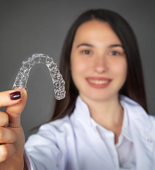 Woman holding her clear braces tray
