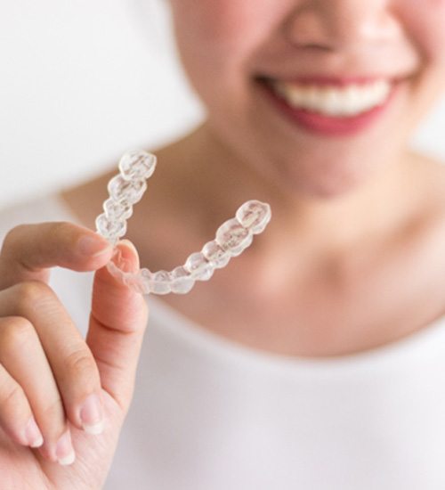 Closeup of patient holding clear aligners in San Ramon