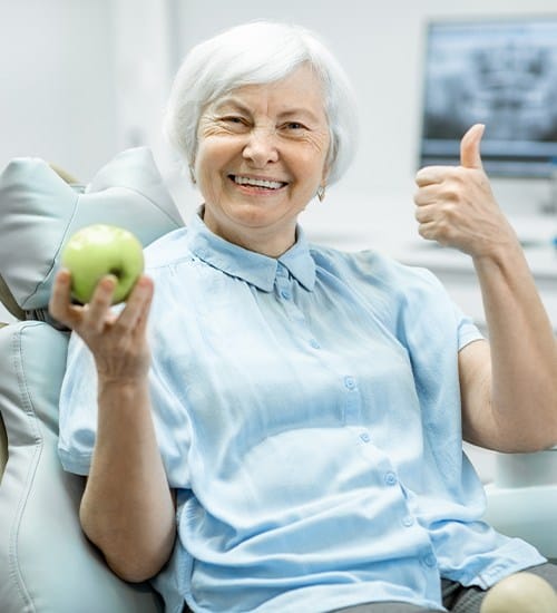 Woman giving thumbs up after smile makeover plan