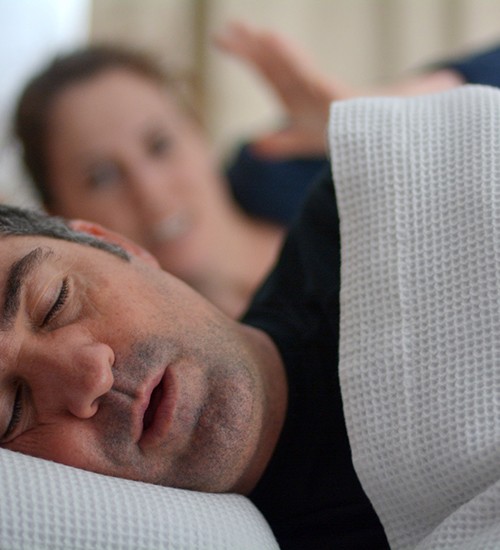 Man with sleep apnea snoring in bed