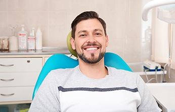 Man smiling while sitting in dental chair