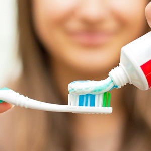 Close up of a woman applying toothpaste to her toothbrush
