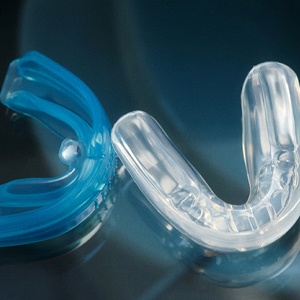 Translucent blue and clear mouthguard with dark background