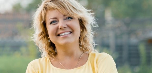 Woman smiling after replacing missing teeth