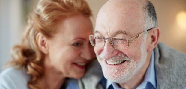 Man and woman with healthy smiles after gum disease treatment