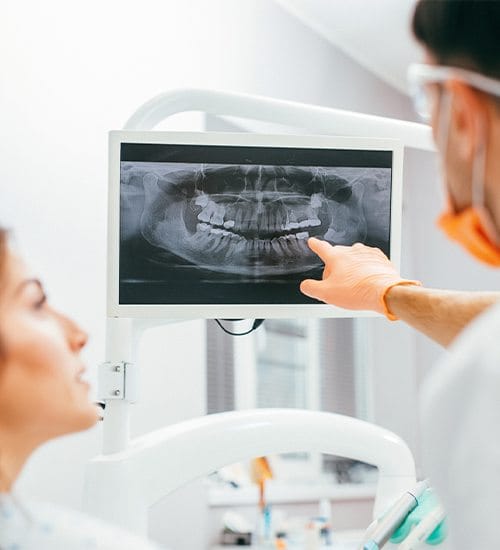 Dentist and patient looking at digital dental x-rays