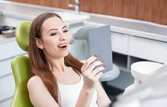 Woman looking at her smile in a mirror