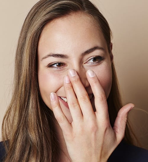 Woman in need to teeth whitening covering her smile