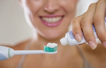 Woman using a teeth whitening toothpaste