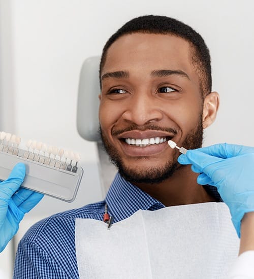 Man's smile compared with tooth shade options