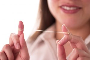 Woman with dental floss. 