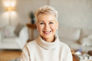 Woman in sweater thinking while smiling