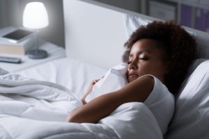 Woman soundly sleeping in white bedding