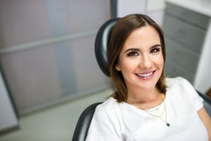 Woman smiling while sitting in a dental chair