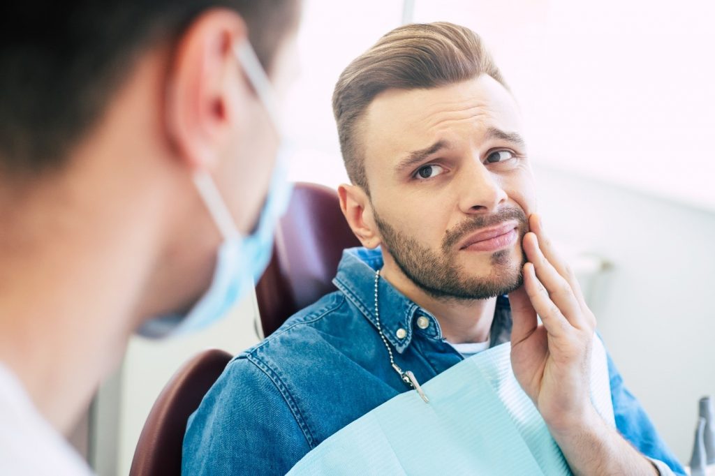 Man with toothache talking to dentist