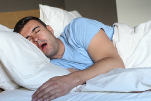 Man with sleep apnea snoring in bed