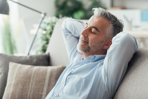 Bearded man with sleep apnea napping on the couch