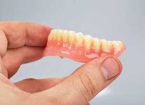 Close-up of holding dentures for lower jaw