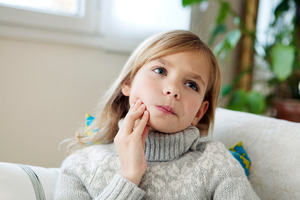 Little girl in sweater with jaw pain